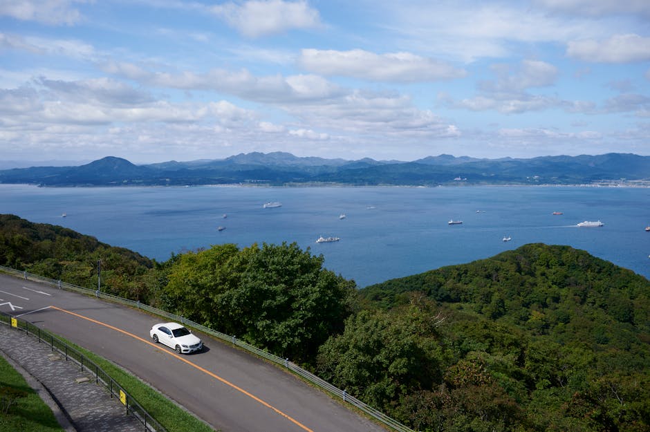 Aerial view of a car on a coastal road overlooking the sea in Hokkaido Japan