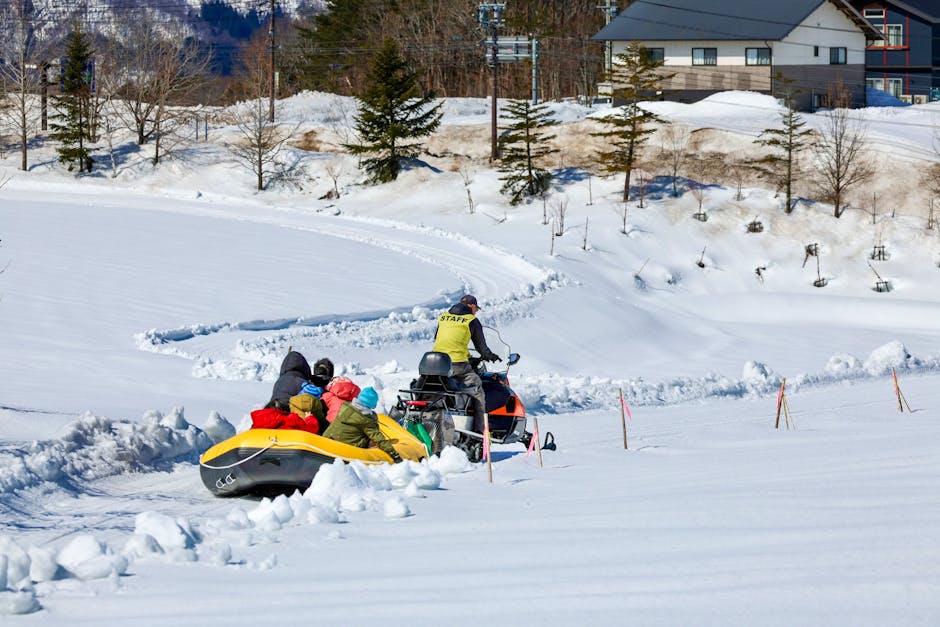 People enjoying snow rafting pulled by snowmobile in winter in Hokkaido Japan