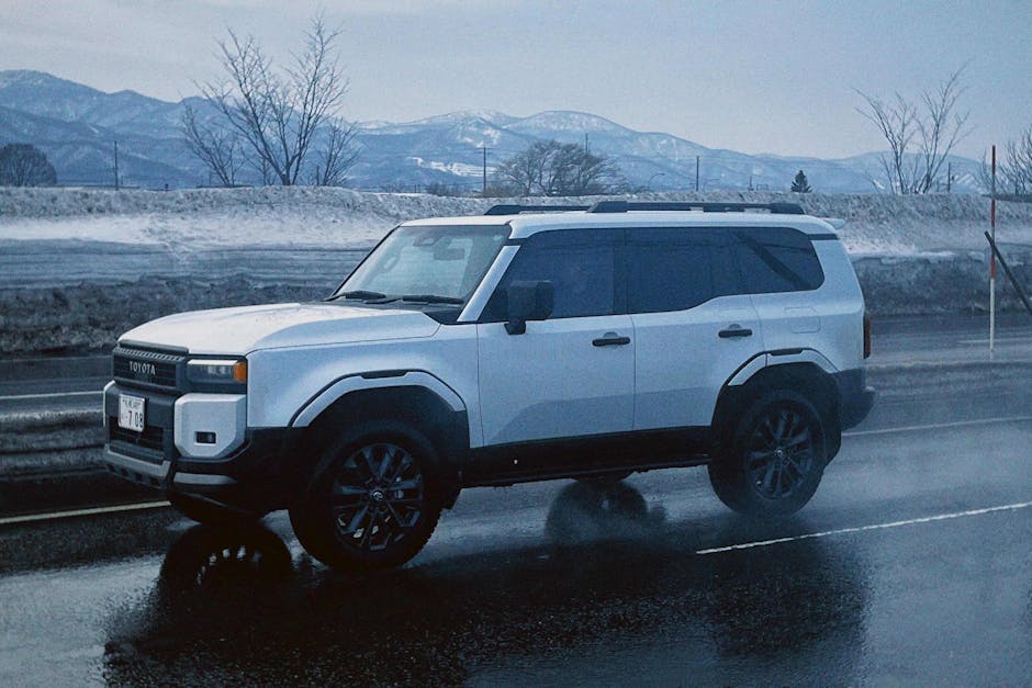 SUV driving on a wet road against snowy mountain backdrop in Sapporo Hokkaido Japan