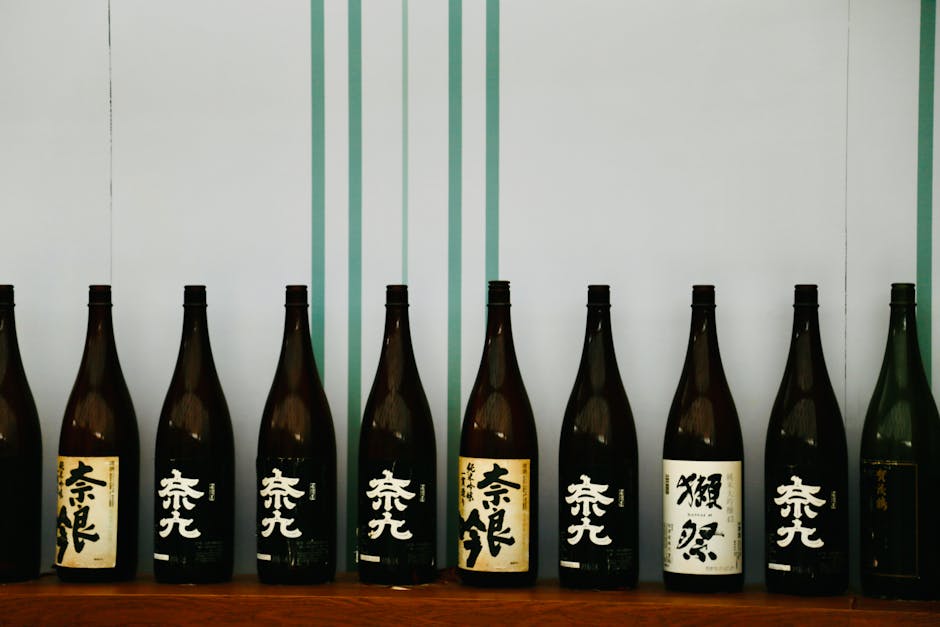 Row of Japanese sake bottles displayed on a wooden shelf