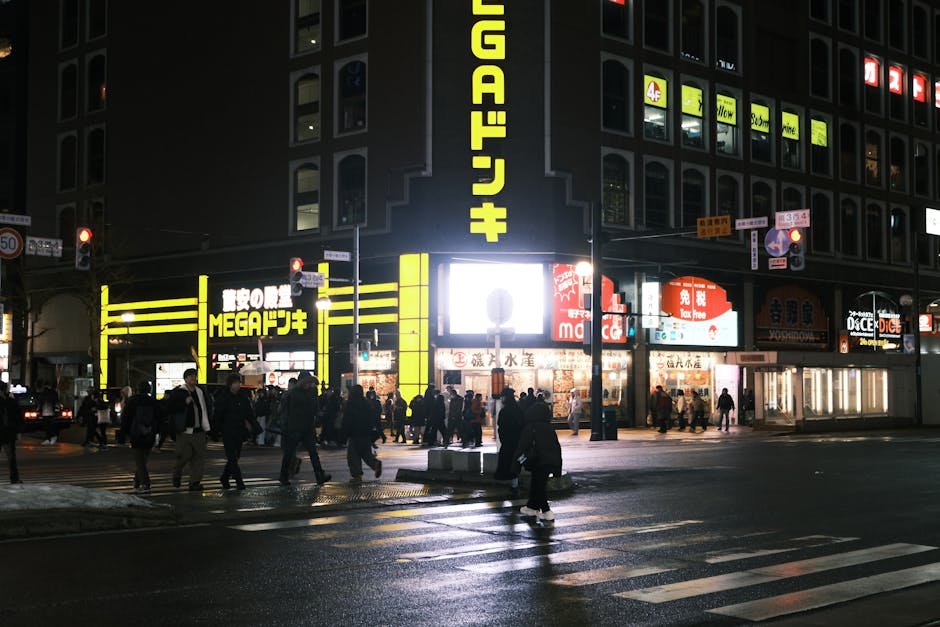 Busy nighttime street in Sapporo Hokkaido with lit storefronts